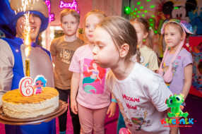 Девочка задувает торт